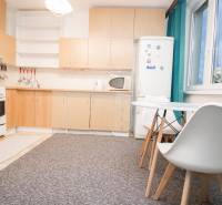 Küche mit weißen Möbeln und Esstisch in einer 4-Zimmer-Wohnung.