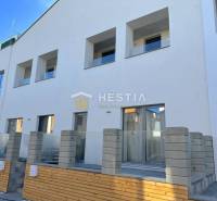 Neubau mit mehreren Balkonen und einer 2-Zimmer-Wohnung, Betonzaun und Terrasse.