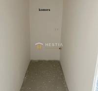 Ein kleiner Abstellraum in einer 2-Zimmer-Wohnung mit weißen Wänden und Betonboden.