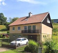 Ein Einfamilienhaus in Liptovské Revúce mit Garage und Garten auf einem Hanggrundstück.