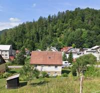 Ein Einfamilienhaus in Liptovské Revúce, umgeben von Grünflächen und weiteren Häusern vor dem Hintergrund eines Waldes.