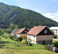 Einfamilienhäuser in Liptovské Revúce mit Berglandschaft und Gärten.