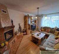 Wohnzimmer in einem Einfamilienhaus mit Kamin, Sofa und Holzboden.