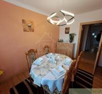 Der stilvolle Speisesaal eines Einfamilienhauses, hervorgehoben durch ein leichtes und ordentliches Tischtuch, aber auch durch ein außergewöhnliches Licht.