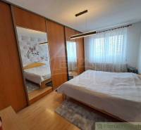 Schlafzimmer im Einfamilienhaus mit Spiegelschränken und Holzboden.