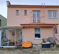 Ein Einfamilienhaus in Veľké Ripňany mit einer verglasten Terrasse und einem gepflasterten Hof.