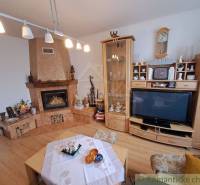 Wohnzimmer in einem Einfamilienhaus mit Kamin, Holzbodenoptik und Vitrine.