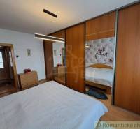 Schlafzimmer in einem Einfamilienhaus mit Holzboden und einem großen Schrank.