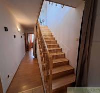 Der Flur eines Einfamilienhauses mit einer Holztreppe und einem Boden in Holzoptik.
