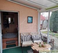 Ein Wintergarten im Einfamilienhaus mit bequemen Sitzgelegenheiten und Blick in den Garten.
