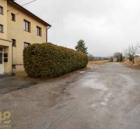 Außenansicht einer 5- oder mehr-Zimmer-Wohnung in Stará Lesná mit sichtbaren Büschen und einer Straße.