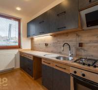 Küche in einer Wohnung mit 5 oder mehr Zimmern mit eleganter Küchenzeile und Bodenbelag in Holzoptik.