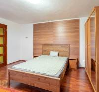 Schlafzimmer in einer Wohnung mit 5 oder mehr Zimmern mit Holzboden, Holzmöbel.
