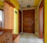 Eingangshalle in einer Wohnung mit 5 oder mehr Zimmern mit gelben Wänden und Holztüren.