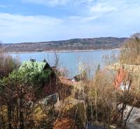 Blick von der Hütte in Holčíkovce auf das Zajačia Debra mit dem See und den Wäldern im Hintergrund.