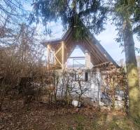 Der Bau der Hütte auf dem Zajačia debra in Holčíkovce, umgeben von Wald und Grün.