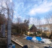 Baumaterial neben der Hütte auf Zajačia debra in Holčíkovce mit Blick auf die Wasserfläche.
