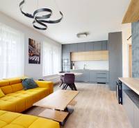 Wohnzimmer in einer 3-Zimmer-Wohnung mit Holzboden und gelbem Sofa.
