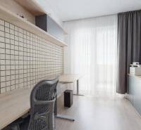 Ein Arbeitszimmer in einer 3-Zimmer-Wohnung mit einem großen Tisch, Stauraum und einem Boden in Holzoptik.
