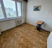 Ein Zimmer mit einem Holzboden in einer 3-Zimmer-Wohnung, einem Bild und einem Tisch.