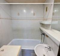 Badezimmer in einer 3-Zimmer-Wohnung mit Badewanne, Waschbecken und Waschmaschine.