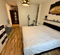 Schlafzimmer mit Doppelbett und Holzboden in einer 3-Zimmer-Wohnung.