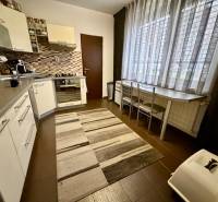 Küche in einer 3-Zimmer-Wohnung mit dunklem Boden und großem Fenster.