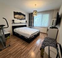 Schlafzimmer in einer 3-Zimmer-Wohnung mit Holzboden und einem Heimtrainer.