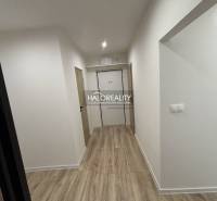 Flur in einer 3-Zimmer-Wohnung mit Holzboden und weißen Wänden.