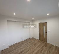 Ein geräumiger Raum mit Holzboden und eingelassener Beleuchtung in einer 3-Zimmer-Wohnung.