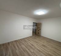 Ein geräumiges Zimmer in einer 3-Zimmer-Wohnung mit einem Boden in Holzoptik und weißen Wänden.