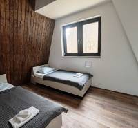 Ein Zimmer mit zwei Betten, Holzverkleidung und einem Boden mit Holzdekor in einer Hütte.