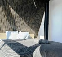 Bett mit gestreifter Decke und Holzwänden in der Hütte.