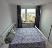 Schlafzimmer in einer 3-Zimmer-Wohnung mit großem Fenster und Einbauschrank.