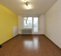 Ein Zimmer in einer 3-Zimmer-Wohnung mit einem Boden in Holzoptik und einer gelben Wand.