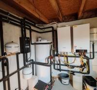 Technische Heizungsanlage in einem Einfamilienhaus mit verbundenen Rohren und Boiler.