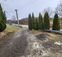 Straße und Bäume neben dem Einfamilienhaus in der Hauptstraße in Piskorovce.