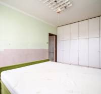 Schlafzimmer mit großem Bett und geräumigem Schrank in einer 2-Zimmer-Wohnung.