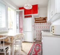 Küche in einer 2-Zimmer-Wohnung mit weißen Möbeln und roten Schränken.