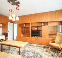 Wohnzimmer in einer 2-Zimmer-Wohnung mit einer Wohnwand aus Holz und Retro-Möbeln.