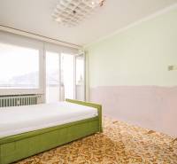 Schlafzimmer mit Bett und Teppich in einer 2-Zimmer-Wohnung mit Balkon.