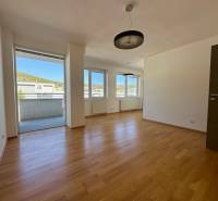 Wohnzimmer in einer 4-Zimmer-Wohnung mit Holzboden und Balkon.