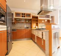 Küche in einer 4-Zimmer-Wohnung mit Holzelementen und Edelstahlgeräten.
