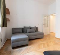 Graues Sofa mit Kissen und Boden mit Holzdekor in einer 4-Zimmer-Wohnung.