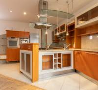 Küche in einer 4-Zimmer-Wohnung mit Insel und Boden in Holzoptik.