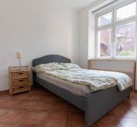 Schlafzimmer in einer 4-Zimmer-Wohnung mit Bett, Nachttisch und großem Fenster.