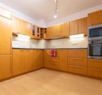 Küche in einer 2-Zimmer-Wohnung mit Holzboden und Einbaugeräten.