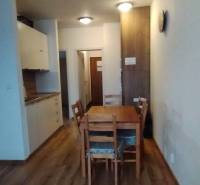 Esszimmer in einer 2-Zimmer-Wohnung mit Holzboden und Holztisch.