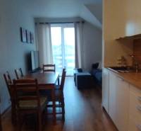 Küchenzeile mit Esstisch und Holzboden in einer 2-Zimmer-Wohnung.