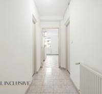 Flur in einer 2-Zimmer-Wohnung mit weißen Wänden und Fliesen.